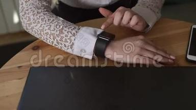 一只商务女士手的特写镜头，她用智能手表查看信息。